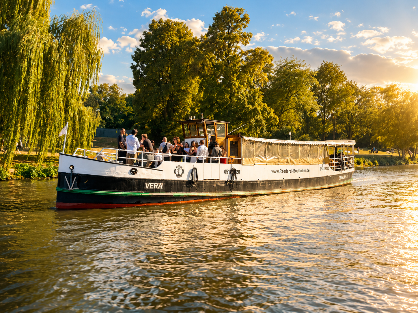 MS Vera bei sommerlicher Fahrt an grünen Ufern